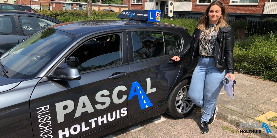 Foto van Francisca naast de auto van Rijschool Pascal Holthuis
