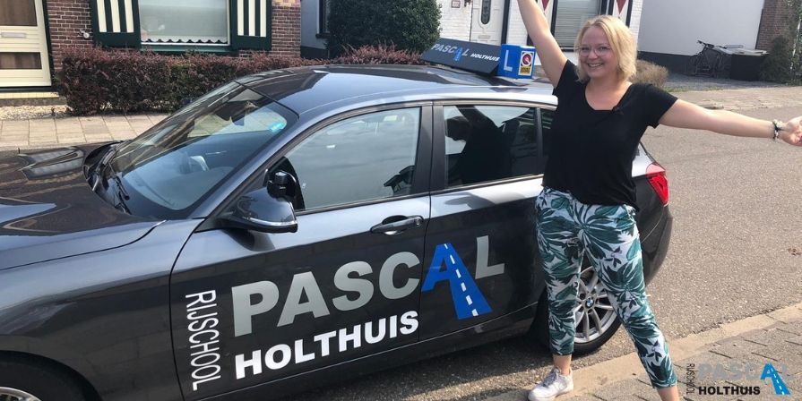Anne naast de auto van Rijschool Pascal Holthuis